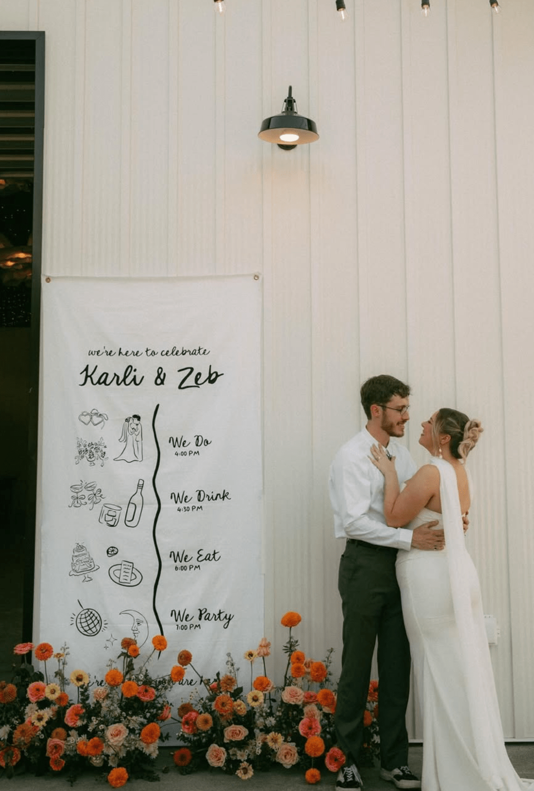 Barn And Blossom Nursery-PNW Weddings-Spokane-Bride And Groom Outside Of Modern White Barn Surrounded By Whimsical Orange Flowers